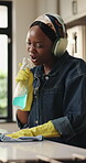 Cleaning, singing and spray bottle with black woman in kitchen of home for chores or housework. Headphones, music and rag with excited African person wiping counter in apartment for hygiene routine