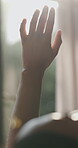Hand, sunlight and person at resort with window, gratitude and reflection on holiday trip. Closeup, daydream and back in bedroom with new day, travel and calm feeling on beginning of vacation.