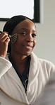 Black woman, jade roller and skincare at mirror in bathroom, circulation and lymphatic drainage in home. African person, smile and reflection with dermatology, facial and benefits for beauty at house