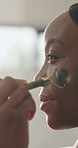 Bathroom, face roller and black woman for skincare, anti aging and lymphatic drainage in home. Morning routine, house and happy person with jade tools for beauty, grooming and facial for wellness