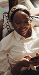 Texting, smile and black woman on sofa with phone, funny chat and meme reaction on social media. Laugh, digital and girl in house with tech, online communication or message notification on app.