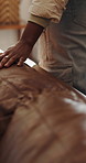 Hand, touch and leather sofa in show house, furniture and holiday home on display in lounge. Person, couch texture and comfort with inspection in property, hospitality service or vacation rental