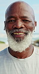 Face, earphones and happy man at beach for fitness, cardio wellness and audio for active retirement. Portrait, exercise music and senior black person outdoor, runner and health podcast by ocean