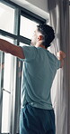 Window, wake up and thinking with man in bedroom for reflection, vision and morning routine. Peace, inspiration and perspective with male person and curtains in home for calm, relax and memory