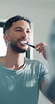 Dental, man and brushing teeth at mirror for health, hygiene and oral wellness in bathroom. Reflection, toothbrush and person cleaning mouth for fresh breath, gum care and morning routine in home