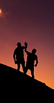 High five, hiking and silhouette of people on mountain with sunset sky for adventure, journey or travel. Climbing, help and space with friends outdoor in nature together for trekking success