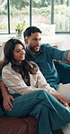 Happy couple, watching tv and relax on couch together,  pointing or talking movie choice for bonding. Remote, streaming film and woman with man chill in home, subscription site and support on weekend