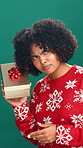 Christmas, shake present and face of woman in studio for holiday, giveaway and festive season. Happy, December and portrait of person with box for celebration, xmas sale and gift on green background