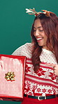 Pointing, christmas and face of woman with gift box in studio for festive celebration, holiday or event. Happy, giveaway and portrait of person with xmas present for tradition by green background.