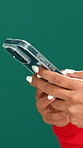 Hands, smartphone and texting in studio for contact, scroll or chat with mockup space on green background. Person, phone and click with mobile app, communication and check post on social network