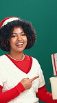 Face, Christmas and woman with presents, pointing and happy for December discount offer and studio. Green background, festive season and black person with gifts, announcement and promotion for xmas