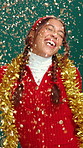 Christmas, dance and woman with confetti in studio for holiday, vacation and festive season. Excited, happy and person with energy for party, xmas and celebration with glitter on green background