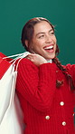 Happy woman, shopping bag and christmas with selfie in studio for photography on a green background. Female person, model or smile with mobile smartphone for picture, capture moment or festive memory