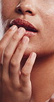 Skincare, woman and apply scrub to lips in studio, exfoliate treatment and soft texture for wellness. Self care, dermatology and person with product for smooth aesthetic, cosmetics and sugar mask.
