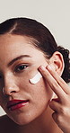 Face, woman and apply cream for skincare, natural dermatology or sunscreen product. Lotion, cosmetics and portrait of model with moisturizer for acne treatment, beauty and white background in studio