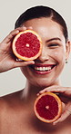 Face, woman and grapefruit for skincare in studio with beauty, hydration and facial healing. Smile, person and organic fruit with natural glow, healthy skin and collagen treatment on white background