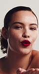 Lipstick, woman face and blow kiss in studio, beauty aesthetic and mouth color for glamour finish. Cosmetology, self care and happy person with matte balm for pigment, wellness and white background.
