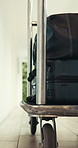 Bags, luggage and transport with hotel trolley for customer service, travel convenience or safety. Cart, suitcase and packed baggage on wheels for moving personal cargo, delivery or transfer in lodge