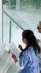 Top view, medical team and walking in hospital, talking or review healthcare records on stairs. People, nurse or clinic manager with document above for planning, schedule or insurance info from back