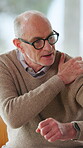Senior man, talking and arm pain at house with discomfort, muscle strain and arthritis symptoms. Elderly person, explaining and massage shoulder of joint stiffness, sore inflammation and fibromyalgia