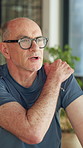 Discussion, senior man or shoulder pain in consultation with discomfort, explain symptoms or checkup. Retirement health, old person and conversation in physio for joint inflammation and muscle strain