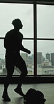 Start, fitness and silhouette of man in gym for sparring, shadow boxing workout and training. Mma challenge, exercise and begin with person at window of sports club for boxer, punch and walk