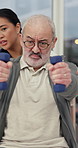 Elderly man, physiotherapist and dumbbells, talk or exercise for healing muscle at wellness clinic. Senior person, healthcare expert and woman with recovery, advice and rehabilitation for injury