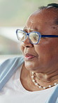 Thinking, glasses and senior woman in home with memory, reflection or nostalgia in living room. Alzheimers, grief and elderly female person in retirement with planning for day on sofa in house.