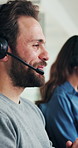Call center, consultation and man in office, smile and customer service with system solution. Happy person, communication or employee in workplace, conversation and help desk with headset or sales