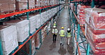 Above, logistics and people in warehouse, planning or organize inventory with conversation. Group, walking or employees with safety, distribution or talking with teamwork, production or manufacturing