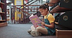 Reading, girl and kid in library, education and knowledge with creativity, development and fantasy. Student, child and growth with storytelling, learning and hobby with bookshelf and language