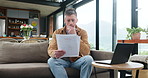 Documents, reading and man in home for budget planning, financial loan or debt invoice. Paperwork, living room and mature person with mortgage expenses, bills or think of taxes with asset management