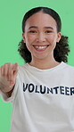 Volunteer, point and face of woman on green screen for community service, ngo choice or pride. Humanitarian outreach, non profit and social responsibility with portrait of person on studio background
