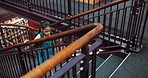 Child, backpack and steps in library for education, student and walking for learning or knowledge from above. Girl, growth and development for literacy, study or project research at academy campus