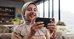 Happy, muslim woman or watching movie on sofa with phone for streaming show, comedy series or film. Islamic person, smile or tech in home for browsing mobile app, social media video or entertainment.