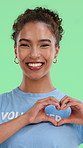 Face, green screen and heart hands with woman volunteer in studio for activism or charity. Community, emoji and humanitarian with smile of happy person in tshirt for help, philanthropy or support