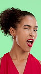 Face, woman and wink for flirting in studio with playful expression, secret romance and valentines day. Smile, person and emoji with romantic sign, admire and eye contact for date on green background