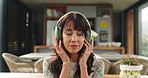 Headphones, happy and mature woman in home listening to audio, calm music and radio on weekend. Apartment, living room and person with streaming subscription for podcast, playlist and sound on sofa