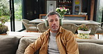 Headphones, relax and mature man in home listening to audio, calm music and breathe on weekend. Apartment, living room and person with streaming subscription for podcast, playlist and meditation
