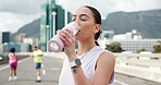 Drinking water, fitness and woman in city, health and rest with training, nutrition and exercise. Outdoor, runner and person with liquid, hydration and thirsty with break, challenge and workout