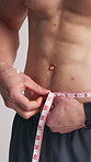 Fitness, man or abdomen in studio with tape measure for weight loss, exercise results or progress. Strong, person or check size of waist for bodybuilding, wellness or muscle goals on white background