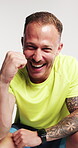 Fitness, face and man with celebration in studio for workout success, performance progress or pride. Laughing, athlete and victory fist on white background for exercise goals and training achievement