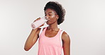 Fitness, drinking and black woman in studio with water for hydration, wellness and health for workout. White background, mockup space and person with bottle, liquid and minerals for exercise recovery