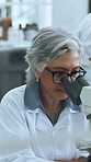 Mature woman, scientist and forensics with microscope for medical study or research in laboratory. Female person, science or healthcare worker with biotechnology for exam results or new discovery