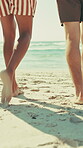 Walking, legs and tourists on holiday, beach and friends on getaway, adventure and outdoor for break. Travel, barefoot and people on summer vacation, back and together in nature, paradise or ocean