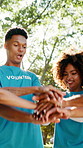 Teamwork, park and hands of volunteer group for charity event, community service and help. Flare, below and people with stack together for collaboration, support and solidarity for outreach program