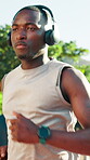 Athlete, man or running with headphones outdoor for fitness, endurance challenge or streaming music. Cardio playlist, black person or jog at park for exercise, sports performance or marathon practice