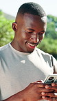 Typing, fitness and black man with phone outdoor for health app, text notification or smile. Mobile, athlete and person in nature for online communication, exercise schedule and track performance