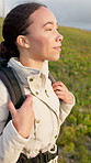 Backpack, breathing and hiking with woman in nature location for adventure, hobby or journey. Mountains, trekking and wellness with happy hiker person outdoor for break, tourism trip or vacation