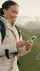 Happy woman, hiking and typing with phone on mountain for social media post, travel and adventure. Person, smile and trekking in nature with tech for blog, text message and online chat on mobile app.
